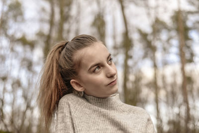 Portrait of teenage girl looking away in forest