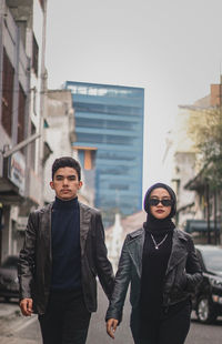 Portrait of young man standing in city