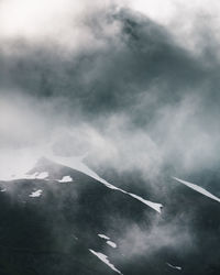 Low angle view of smoke emitting from mountain against sky