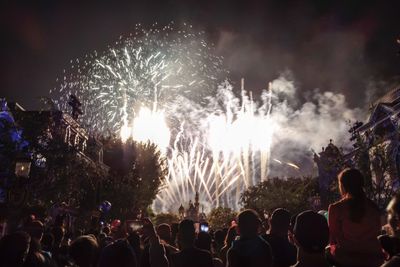 Rear view of crowd watching firecracker at night