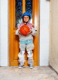 Portrait of boy standing against wall