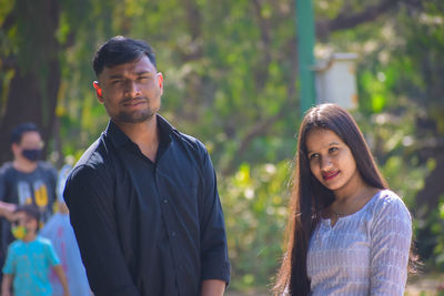 Portrait of young couple standing outdoors