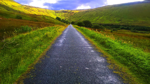 Empty road along countryside landscape