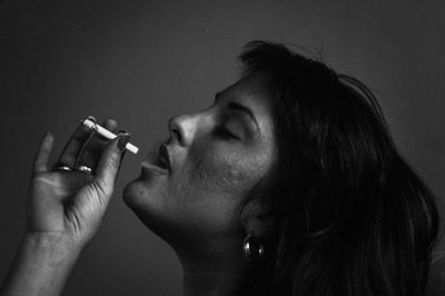 Close-up portrait of a man with hand against gray background