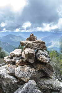 Stack of rocks on mountain against sky