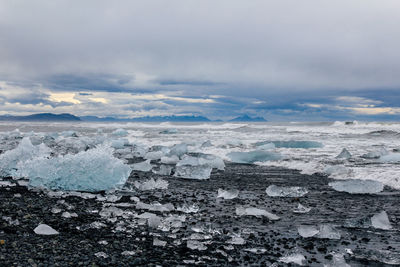 Scenic view of frozen sea against cloudy sky