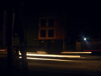 Light trails on street against buildings at night