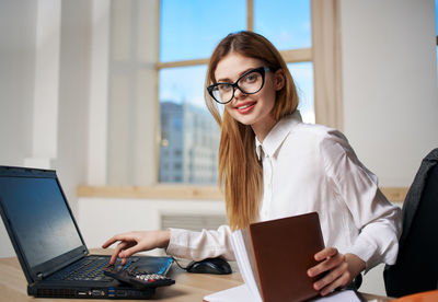 Portrait of smiling woman using laptop