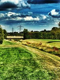 Scenic view of grassy field against cloudy sky