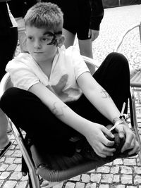 Boy looking away while sitting on chair