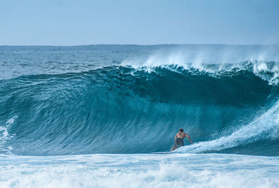 Man surfing in sea against sky