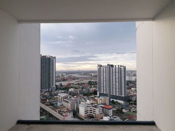 Cityscape against sky seen through window