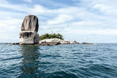 Rock formation in sea against sky