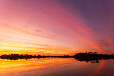 Scenic view of lake against romantic sky at sunset