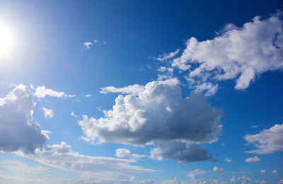 Low angle view of sunlight streaming through clouds