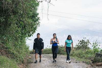 Three young latinos going for a morning hike on a trail through the colombian mountains