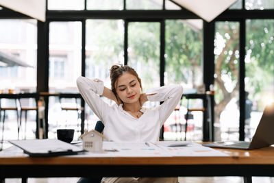 Portrait of young woman using mobile phone at office