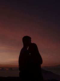 Silhouette man standing against sky during sunset