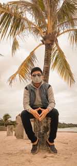 A stylish man with glasses and masks on the beach