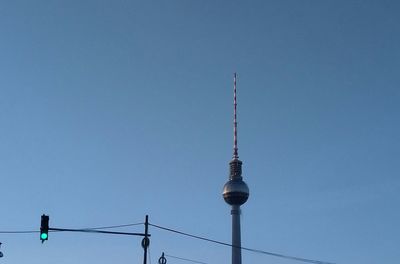 Low angle view of communications tower against blue sky