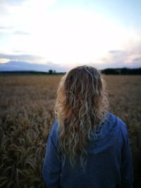 Rear view of woman standing on field