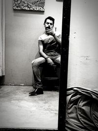 Portrait of young man sitting on wall