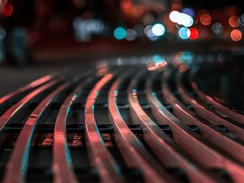 Close-up of empty seats in city at night