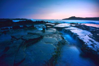 Scenic view of sea against clear sky at sunset