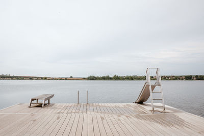 Empty pier on lake against sky
