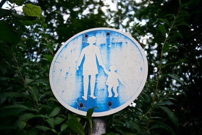 Close-up of road sign against trees