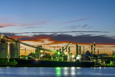 View of factory by sea against sky