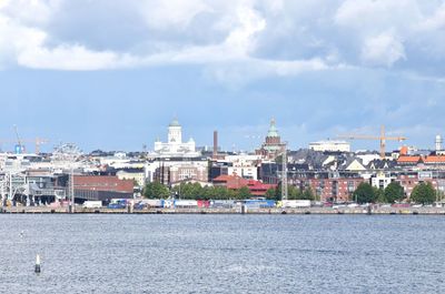 Buildings in city against cloudy sky