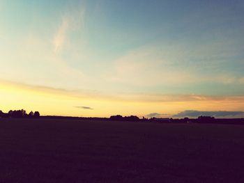 Scenic view of silhouette field against sky during sunset