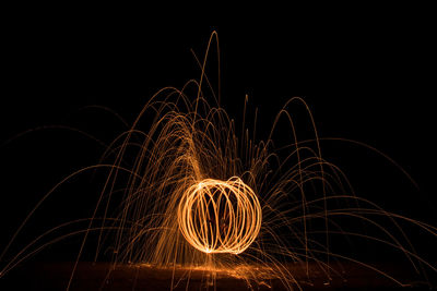 Firework display against sky at night