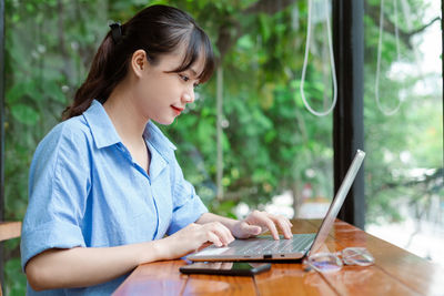 Young woman using laptop at table