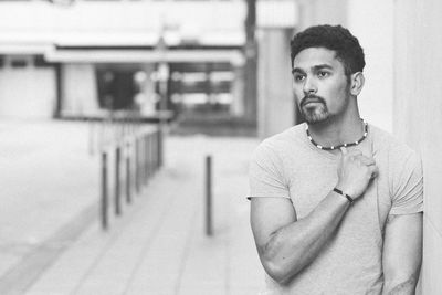 Portrait of young man standing against wall