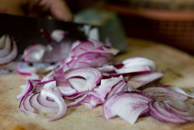 Close-up of hand holding vegetables on cutting board