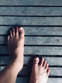 Low section of woman legs on wood