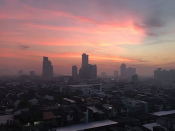 Buildings in city during sunset