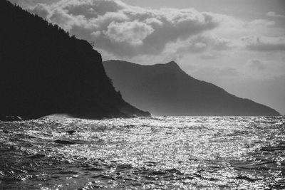 Scenic view of sea and mountains against sky