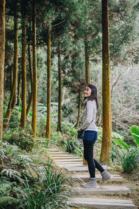 Side view of smiling woman in forest