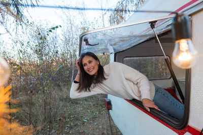 Caucasian woman peeking out of camper window