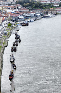 High angle view of sailboats in sea by buildings in city