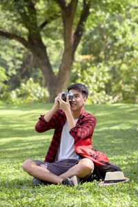 Full length of senior woman sitting on field