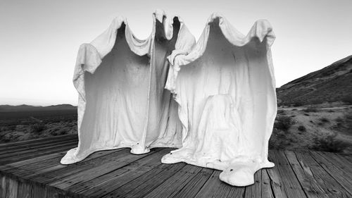 Clothes drying on wood against sky