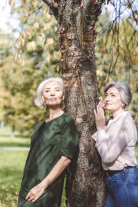 Young woman standing on tree trunk