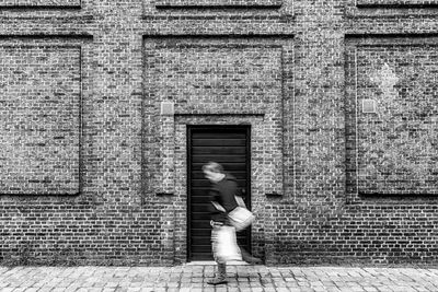 Woman standing by wall