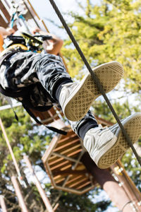 Low angle view of boy on rope in playground