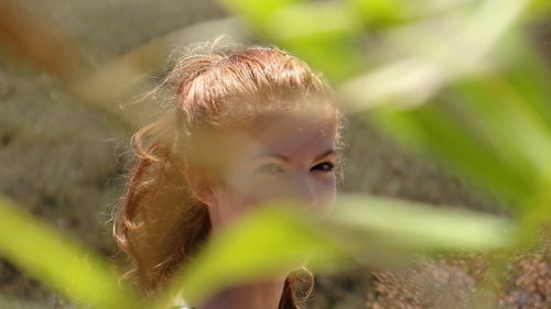 Portrait of young woman seen through leaves