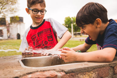 Boys playing with water at fountain